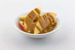 a bowl of sliced apple and peanut butter