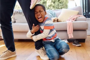 a mum withan angry toddler clamped on her leg