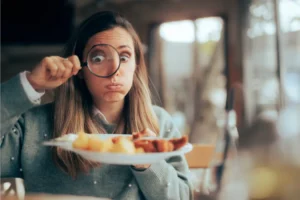 a woman looking through a magnifying glass at her food