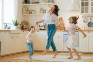 mum and 2 daughters dancing in the kitchen
