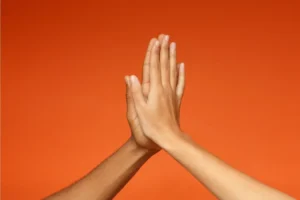 a high five on an orange back ground