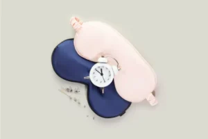 two sleep masks, one pink and one blue plus an alarm clock and some lavender