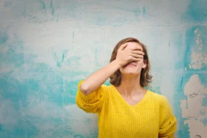 woman covering her face in a guilty way